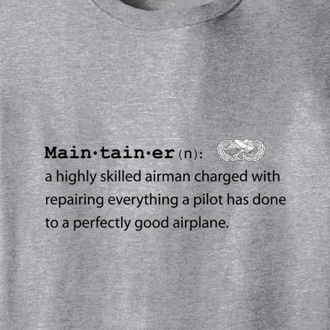 Close-up of a heather gray t-shirt featuring a black printed dictionary-style definition of 'Main·tain·er' with a small white airplane emblem.
