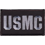 An embroidered rectangular patch with the letters 'USMC' in light gray on a black background, shown against a plain white backdrop.