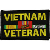 A rectangular embroidered patch with a black background and the words 'VIETNAM VETERAN' in large yellow letters. In the center, there are military service ribbon graphics in red, green, yellow, white, and blue.