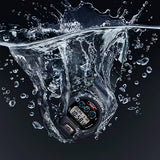 G-SHOCK watch submerged in water with splashes on a dark background