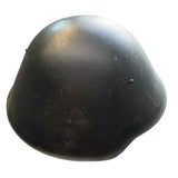 A black molded dome-shaped helmet or protective cap resting on a concrete floor.