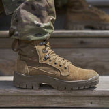 Tan tactical boot on a wooden surface with camouflage pants