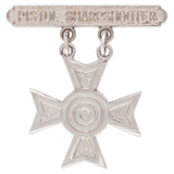 Silver star-shaped badge with 'Pistol Sharpshooter' text on a white background
