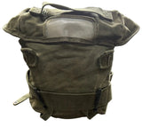 An olive drab green tactical canvas roll-top bag with a clear plastic window on the front, resting on a concrete floor.