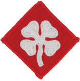 Red square patch with a white four-leaf clover design on a white background
