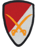 Shield-shaped patch with red, white, and orange design on a white background
