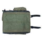 Green bag with straps on a textured concrete surface