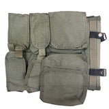 Green tactical vest with multiple pockets and straps on a textured surface