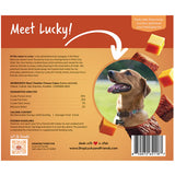 Back of a Lucky dog treat bag package, featuring product branding, ingredients, feeding guidelines, and a photo of a dog eating cheese treats on a warm orange-brown background.
