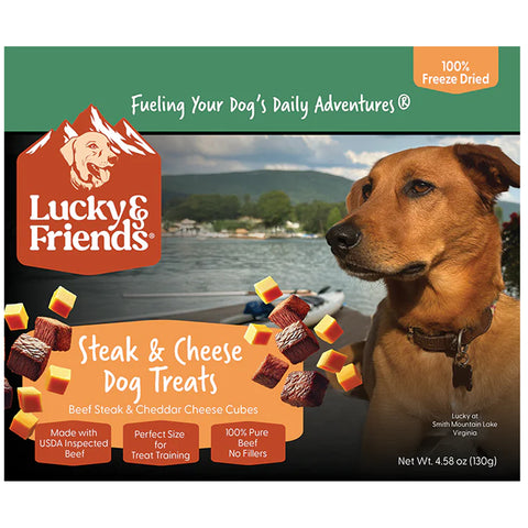 Lucky of Friends Steak & Cheese Dog Treats packaging, featuring a brown dog on the right and floating beef and cheese cubes on the left, with a lake and mountains in the background.