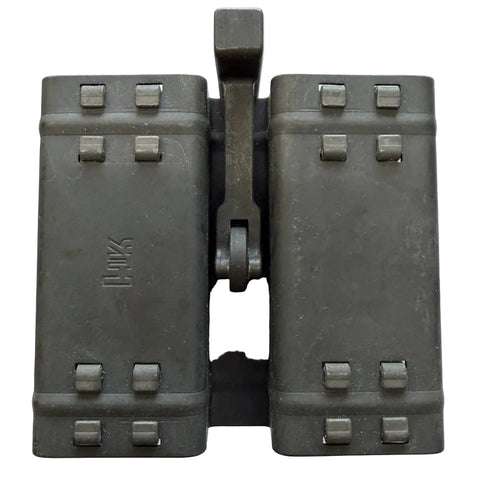 A pair of vintage double magazine binoculars in dark gray metal, featuring a central hinge with a vertical handle and multiple screw terminals on the front.