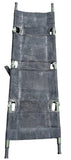 A black canvas military-style litter with olive green frame bars, laid flat on a gray concrete surface.