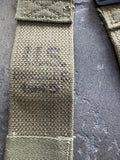 A close-up of a heavy-duty olive green canvas strap with black stamped text reading 'M.S.