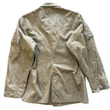 A vintage-style utility jacket with a vertical striped pattern in olive green and beige, laid flat on a textured concrete surface.
