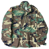 Camouflage military jacket with U.S. Army patches on a white background